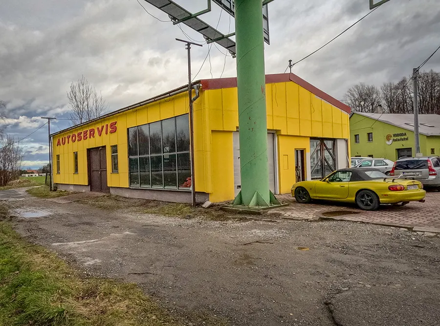 Žlutá budova Autoservisu MAF u hlavní silnice v Hodoňovicích