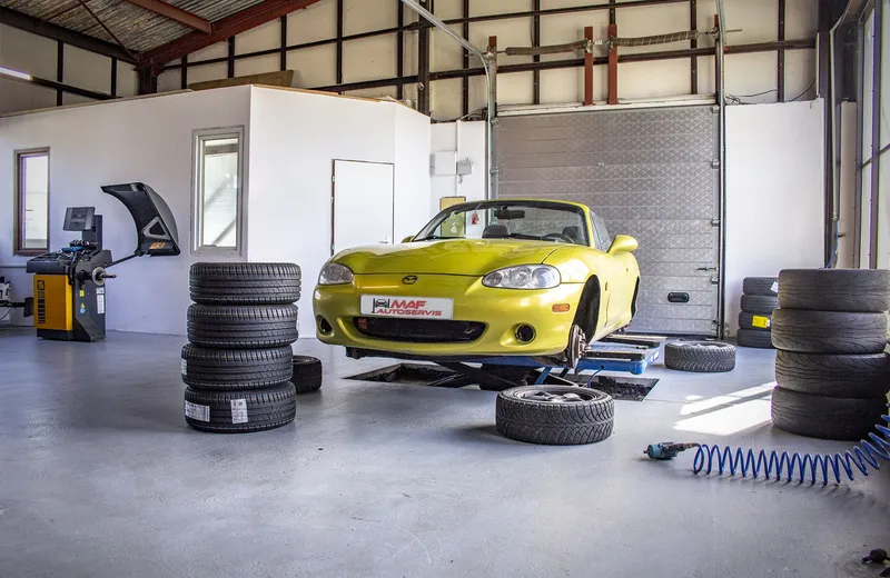Přezouvání pneumatik – žlutá Mazda MX-5 na zvedáku v pneuservisu